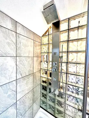 a bathroom with a walk in closet with glass doors at Settlers Suites in Niagara on the Lake