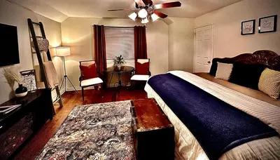 a bedroom with a bed and a ceiling fan at Settlers Suites in Niagara on the Lake