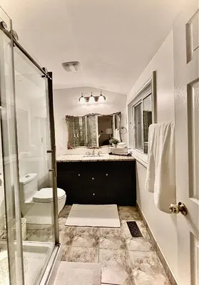 a bathroom with a sink and a toilet and a shower at Settlers Suites in Niagara on the Lake
