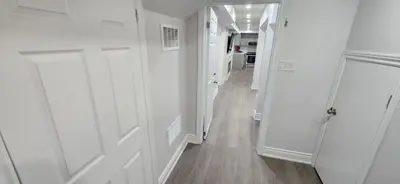 a hallway with white walls and a white door at Cozy 2 Bedrooms & 2 Bathrooms Guest Suite with Electric Fireplace in Georgetown