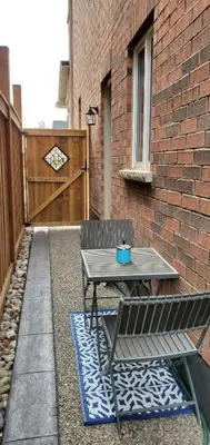 a patio with a table and a bench and a brick wall at Cozy 2 Bedrooms & 2 Bathrooms Guest Suite with Electric Fireplace in Georgetown