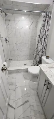 a white bathroom with a toilet and a shower at Cozy 2 Bedrooms & 2 Bathrooms Guest Suite with Electric Fireplace in Georgetown