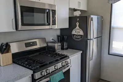 a kitchen with a stove and a stainless steel refrigerator at Subu's Paradise in Niagara in Niagara on the Lake