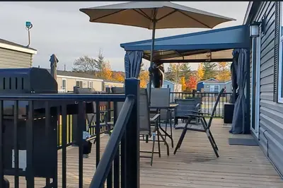 a deck with a table and an umbrella at Subu's Paradise in Niagara in Niagara on the Lake
