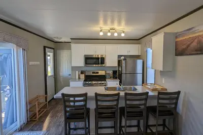 a kitchen with a large island with chairs around it at Subu's Paradise in Niagara in Niagara on the Lake
