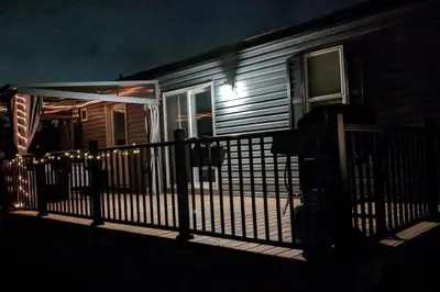a porch of a house with a fence at night at Subu's Paradise in Niagara in Niagara on the Lake