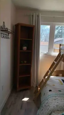 a bedroom with a bunk bed and a book shelf at All Season Cottage close to Long Beach in Wainfleet