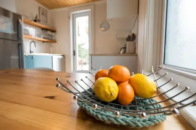 a bowl of oranges and lemons on a kitchen table at Artistic Picton getaway in Picton