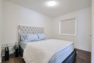 a white bedroom with a large bed with a window at The Ultimate Staycation in Bradford