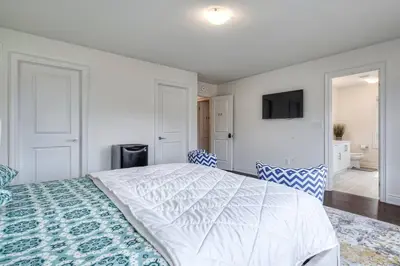 a bedroom with a large white bed with two chairs at The Ultimate Staycation in Bradford