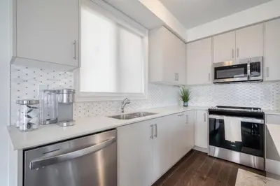 a kitchen with white cabinets and stainless steel appliances at Relax, Refresh and Recharge Peaceful Space in Bradford