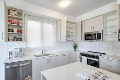 a white kitchen with white cabinets and a window at Relax, Refresh and Recharge Peaceful Space in Bradford