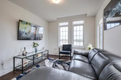 a living room with a leather couch and a table at Unwind Here in a Stylish and Cozy Space in Bradford