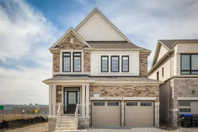 a house with two garage doors in front of it at Unwind Here in a Stylish and Cozy Space in Bradford