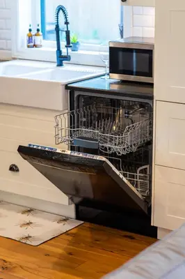 an open dishwasher in a kitchen with a sink at Elegant Elora Home with Stylish Décor in Elora