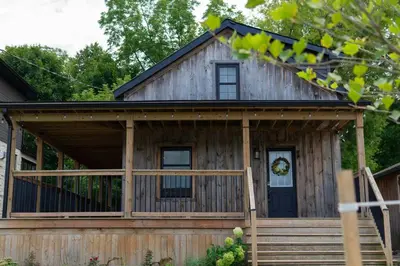 a log cabin with a porch and a front door at Elegant Elora Home with Stylish Décor in Elora