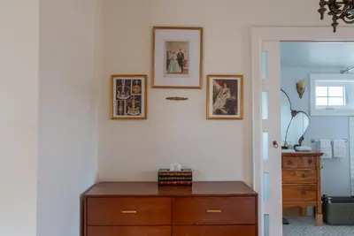 a room with a wooden dresser and pictures on the wall at Elegant Elora Home with Stylish Décor in Elora