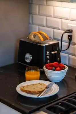 a table with a plate of toast and a bowl of strawberries at Elegant Elora Home with Stylish Décor in Elora