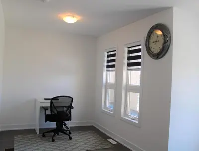 a office with a chair and a clock on a wall at Modern Town House Barrie South in Barrie