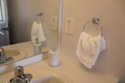 a bathroom with a sink and a mirror and towels at Modern Town House Barrie South in Barrie