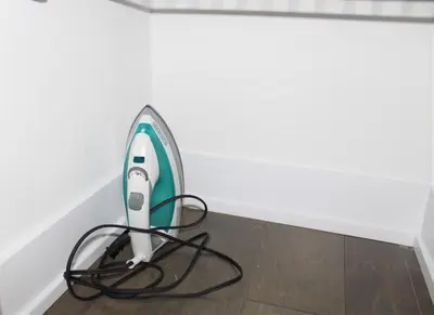 a iron sitting on a floor next to a wall at Modern Town House Barrie South in Barrie