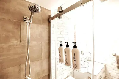 a shower with three bottles on a shelf in a bathroom at Mountainside Studio Bliss Pool, Hot Tubs, At the Mountain in Blue Mountains
