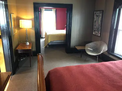 a bedroom with a bed and a mirror and a chair at Lady Hamilton in Stratford