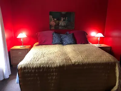 a bedroom with red walls and a bed with two lamps at Lady Hamilton in Stratford