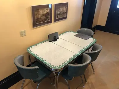 a meeting room with a table with chairs and a laptop at Lady Hamilton in Stratford