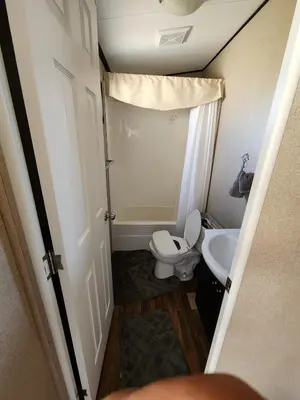 a small bathroom with a toilet and a sink at Falcon Cottages in Niagara on the Lake