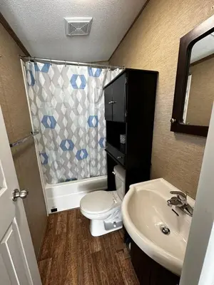a bathroom with a toilet and a sink and a shower at Falcon Cottages in Niagara on the Lake